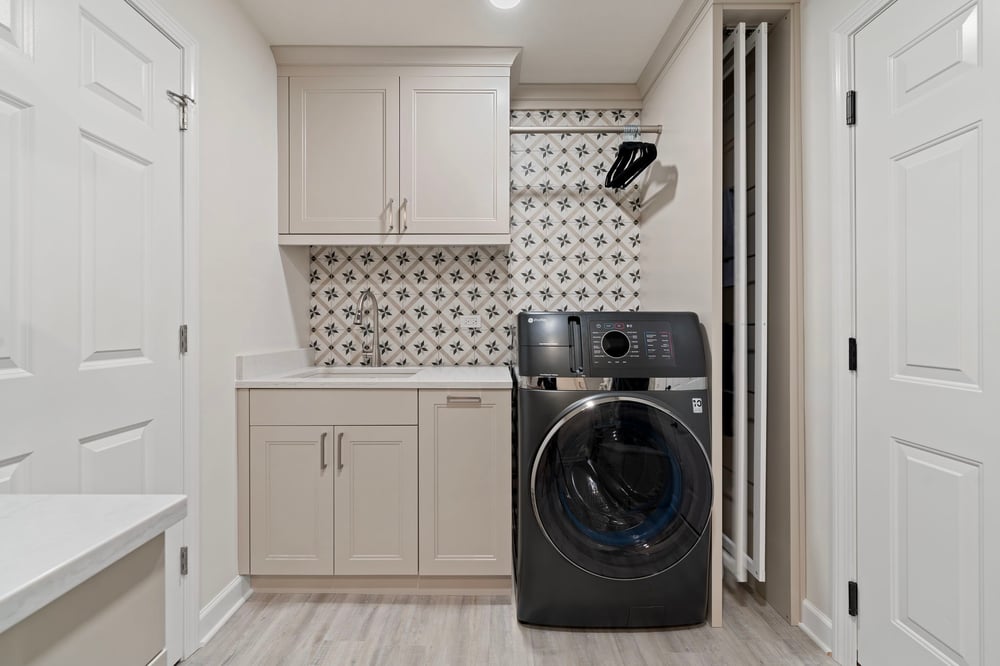 Laundry Room with tile backsplash, pull-out drying racks and a dual washer-dryer