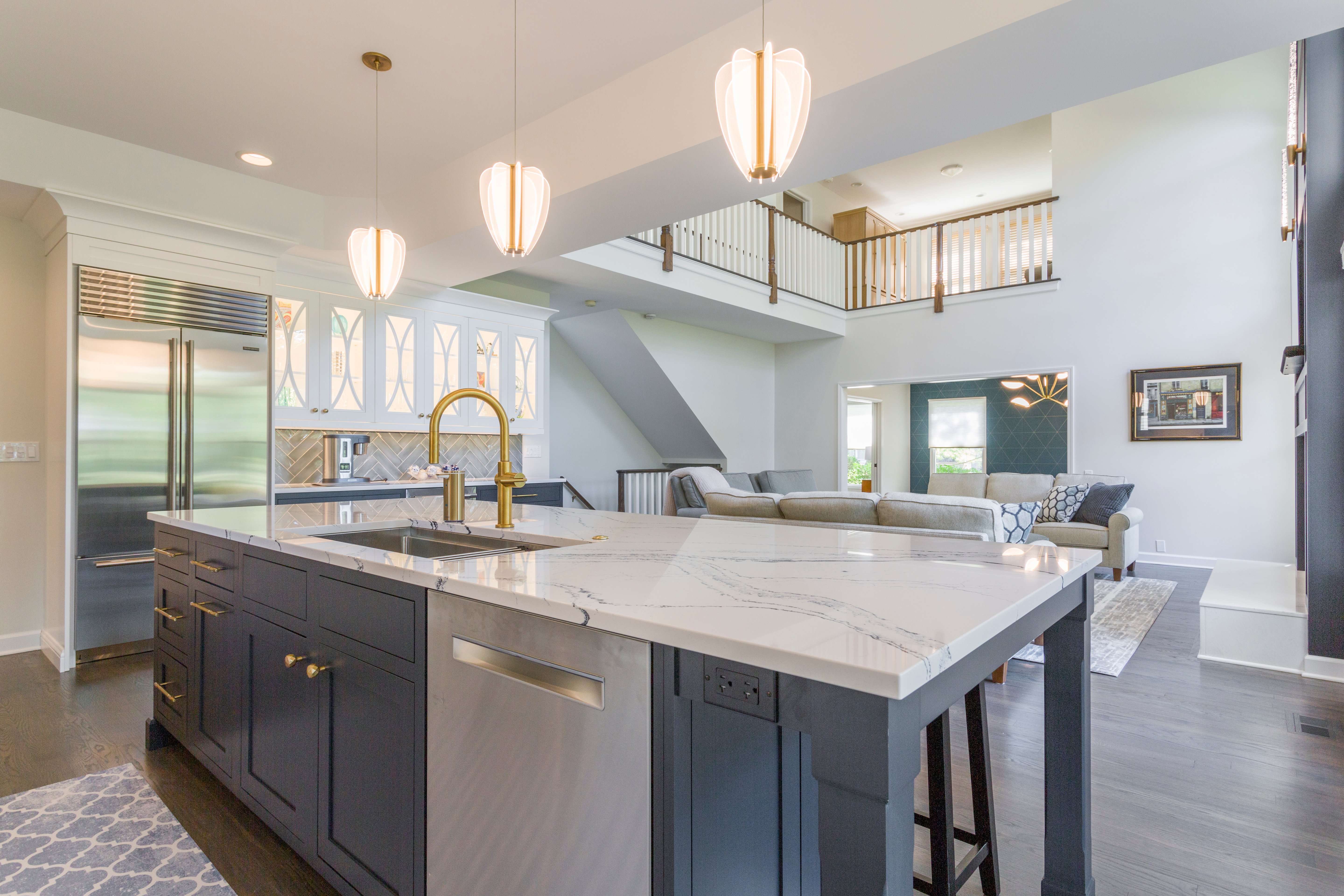 blue and white island with built-in sink with gold hardware and dishwasher