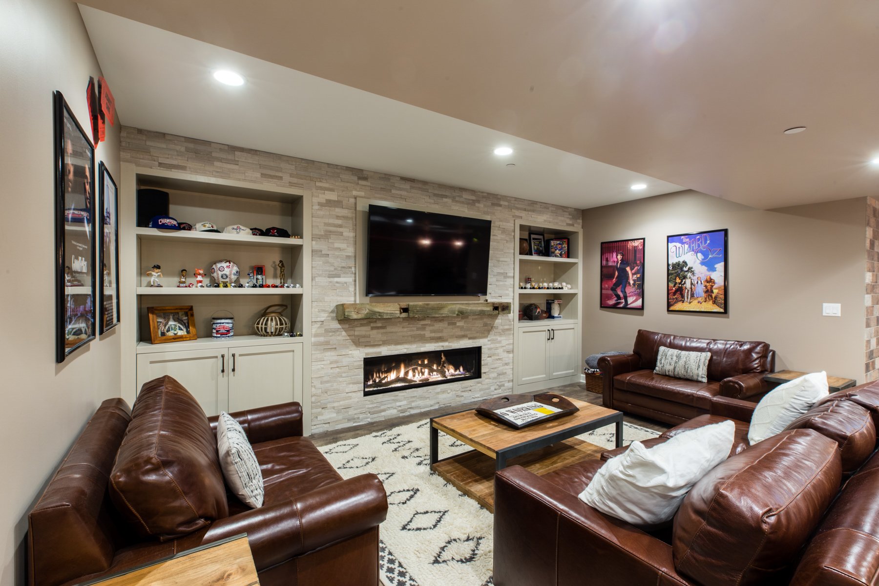 Cream fireplace and built in entertainment wall in a finished basement. 