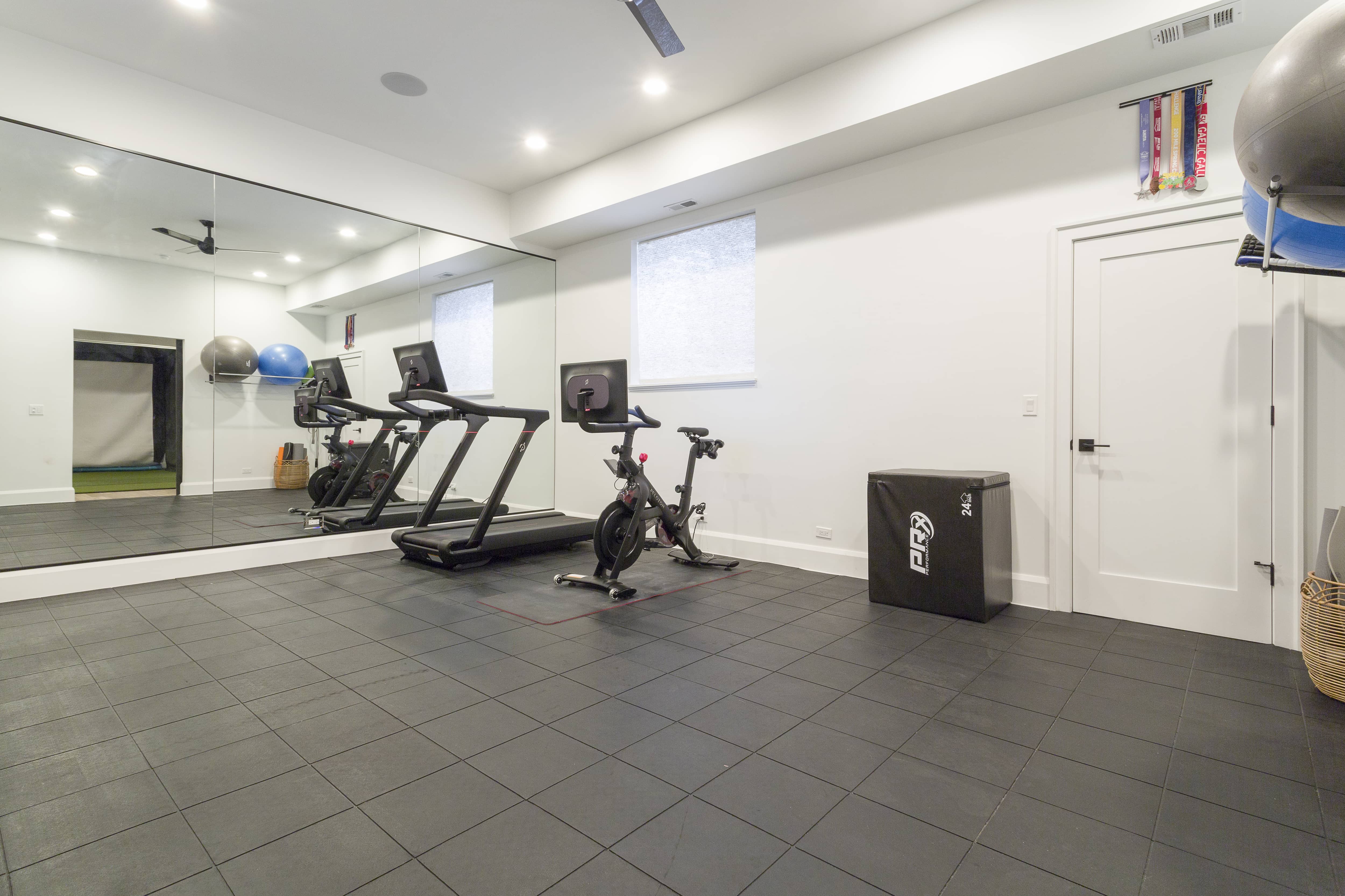 Finished basement work out room. with tiled flooring, elliptical and treadmill. 