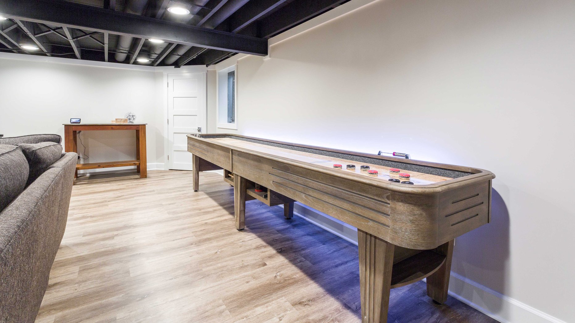 Wood shuffleboard table in a finished basement 