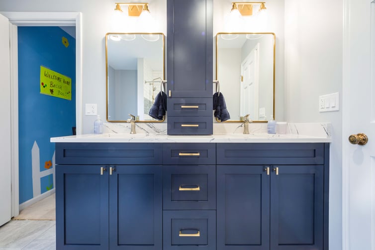 Blue bathroom with gold hardware double vanity and built in storage 