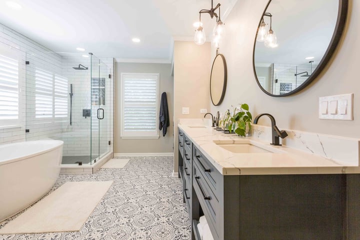 ensuite bathroom with double vanity blue cabinets, stand alone tub, and walkin shower 