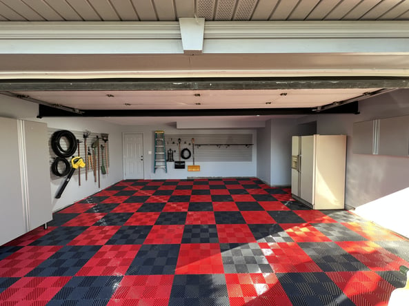 Garage with checkered plastic tiles and slate wall organizers 