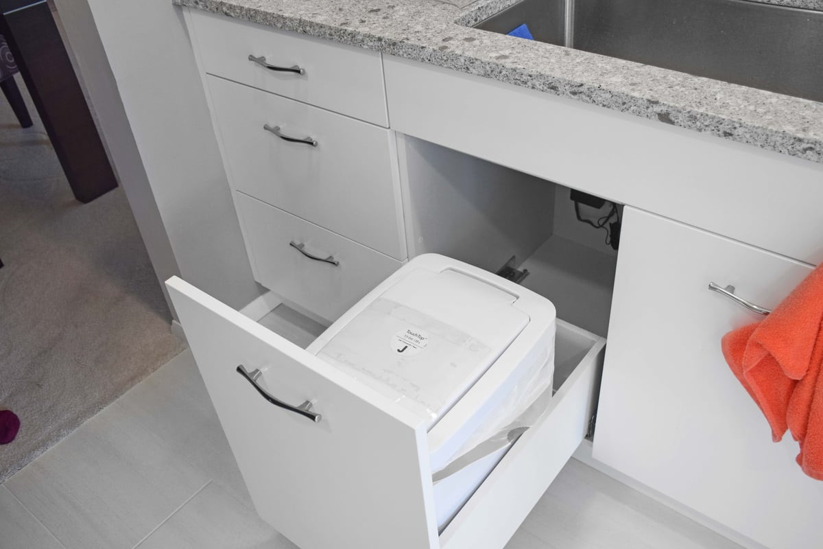 White cabinets with pullout trash can