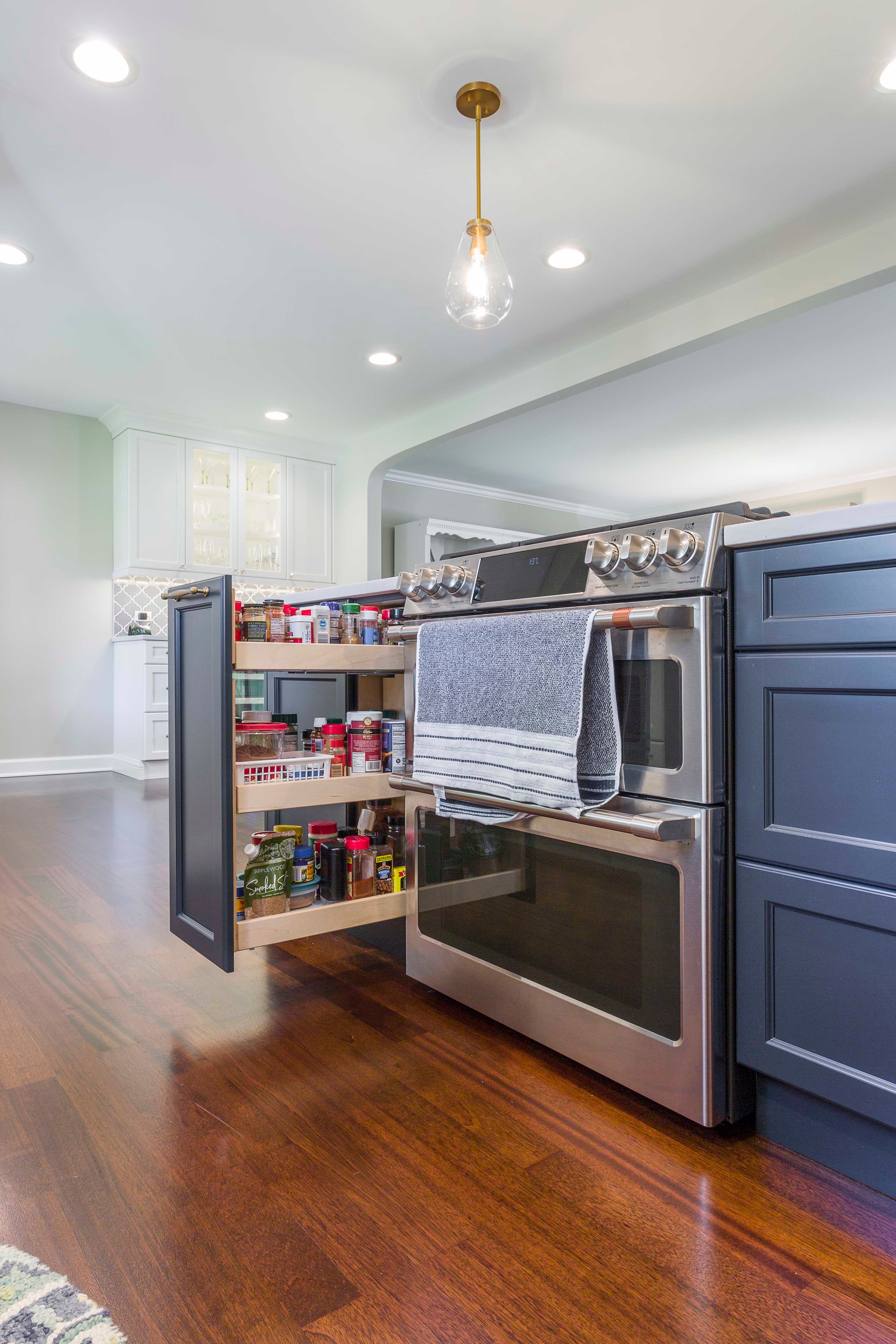 Blue kitchen island with stove and pullout spice rack