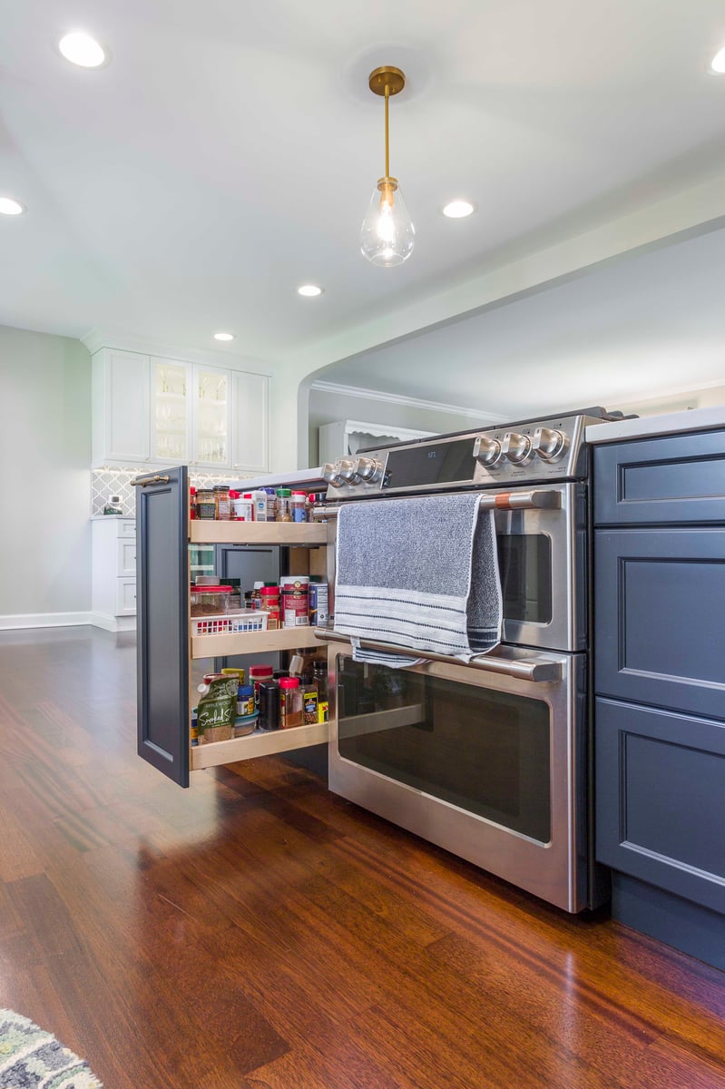 Blue kitchen island with stove and pullout spice rack