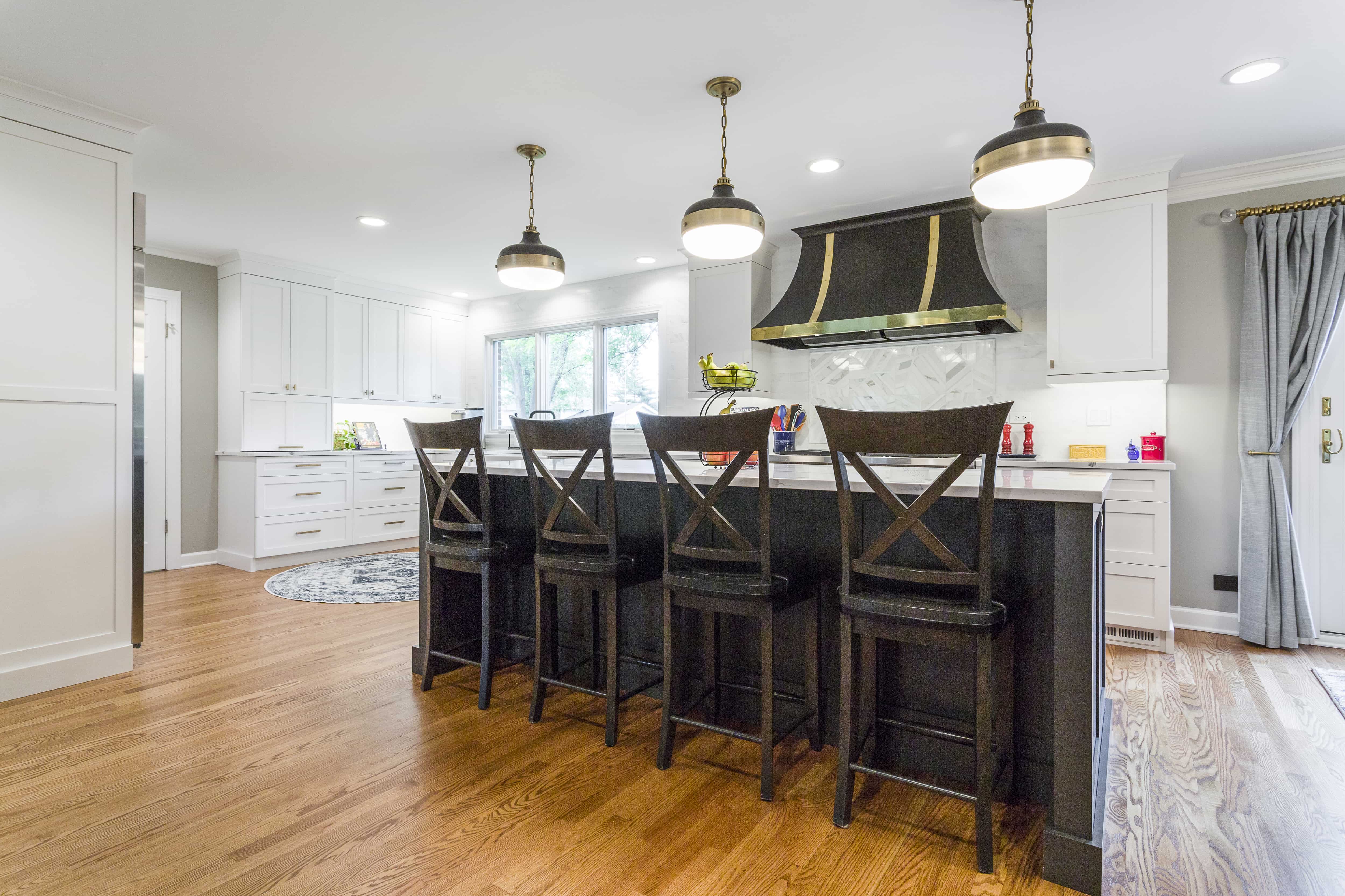 Black, white, and gold kitchen with four seater island 