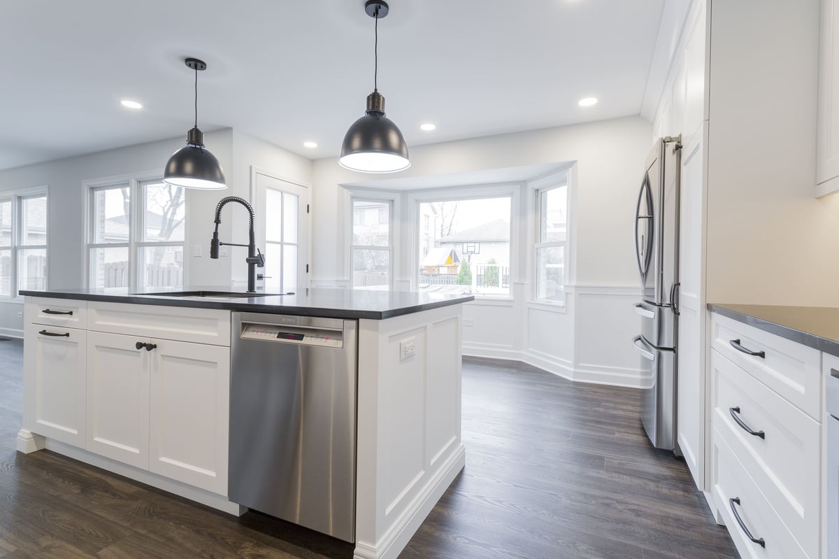 black and white kitchen with large island and stainless steel dishwasher