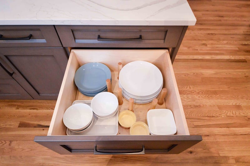 Dishware Organizer with a peg board base and wooden pegs keeping plats and bowls in place