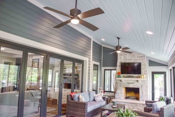 Sunroom with grey paneled walls and a brick fireplace 