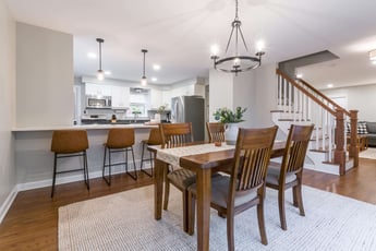 Open concept first floor with large wood dining table and peninsula 