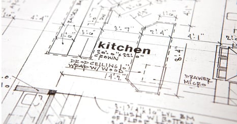 Collage of kitchens and laundry rooms. The middle image is a blue island kitchen with stained wood cabinets in the back, a box hood, and sculptural light fixtures.  then there is a first floor remodle with a stained wood island a grean wall cabinets and a living room in the back. There is a laundry room with blue cabinets.
