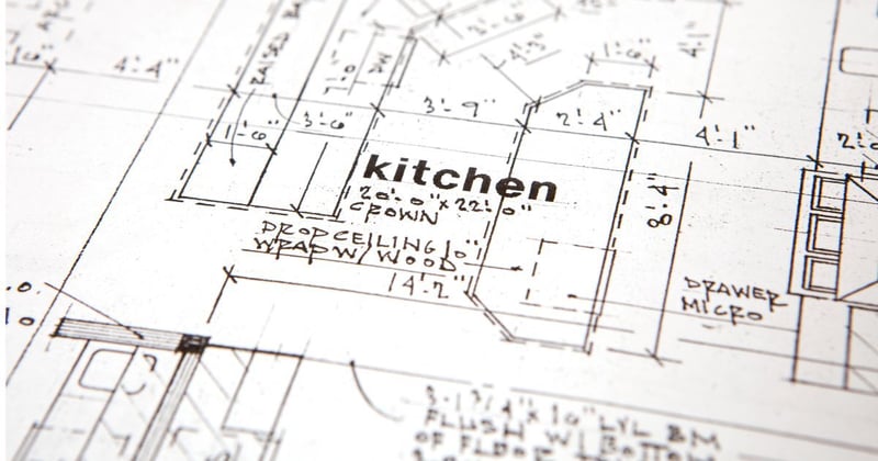 Collage of kitchens and laundry rooms. The middle image is a blue island kitchen with stained wood cabinets in the back, a box hood, and sculptural light fixtures.  then there is a first floor remodle with a stained wood island a grean wall cabinets and a living room in the back. There is a laundry room with blue cabinets.
