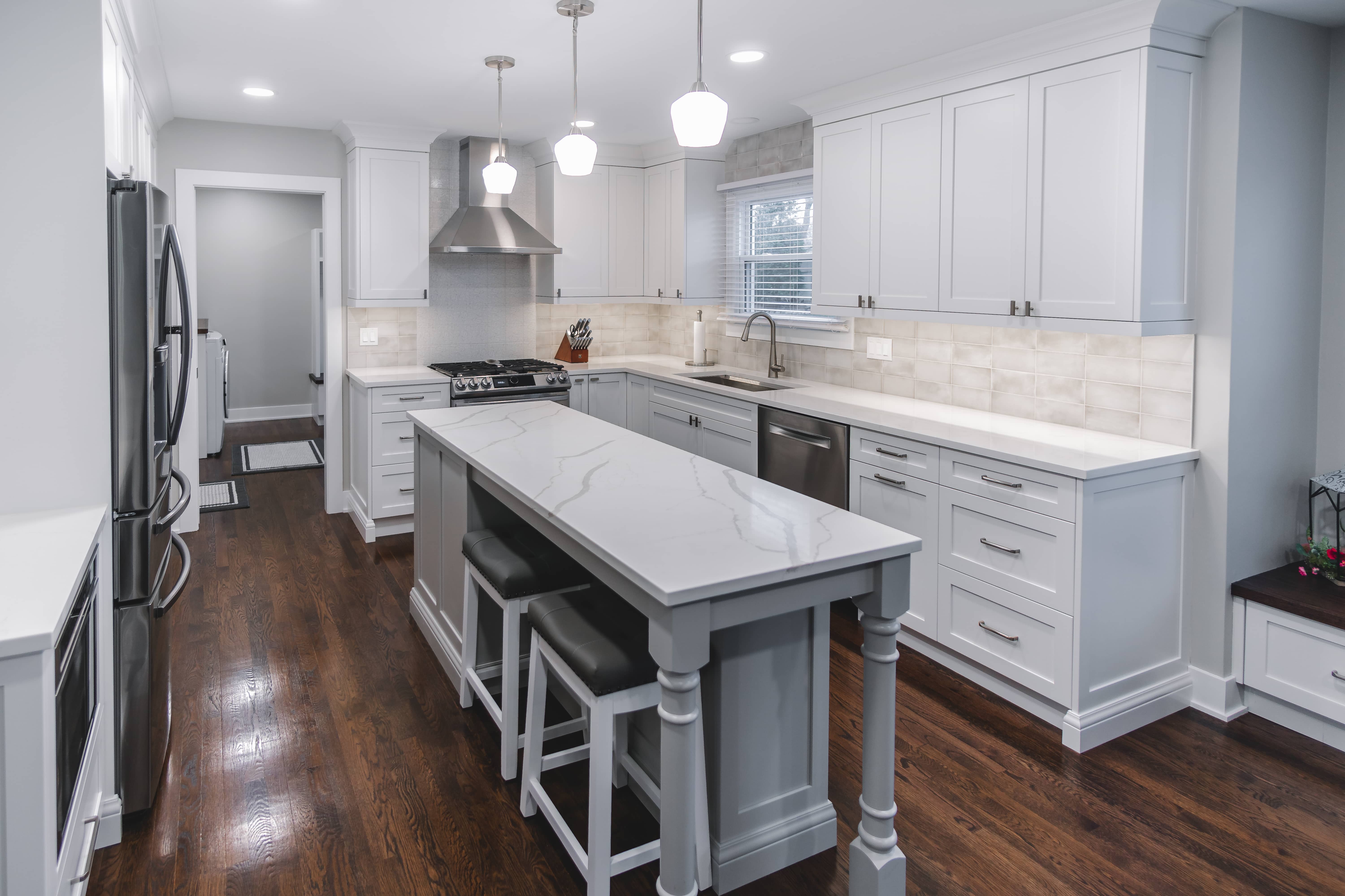 White and gray kitchen with two-seater island and white countertops 